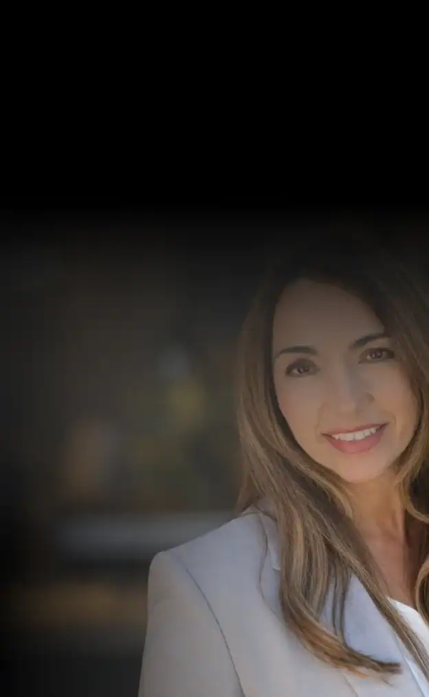 Confident businesswoman with long hair smiling in a professional setting.