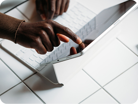 Person using a touch screen laptop on a tiled table