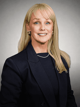 Confident businesswoman with blonde hair in a navy blazer and gold earrings.