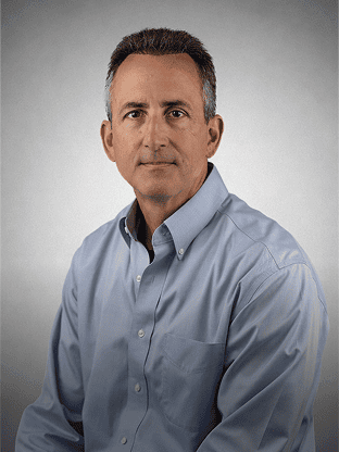 Confident man in a light blue shirt looking at the camera.