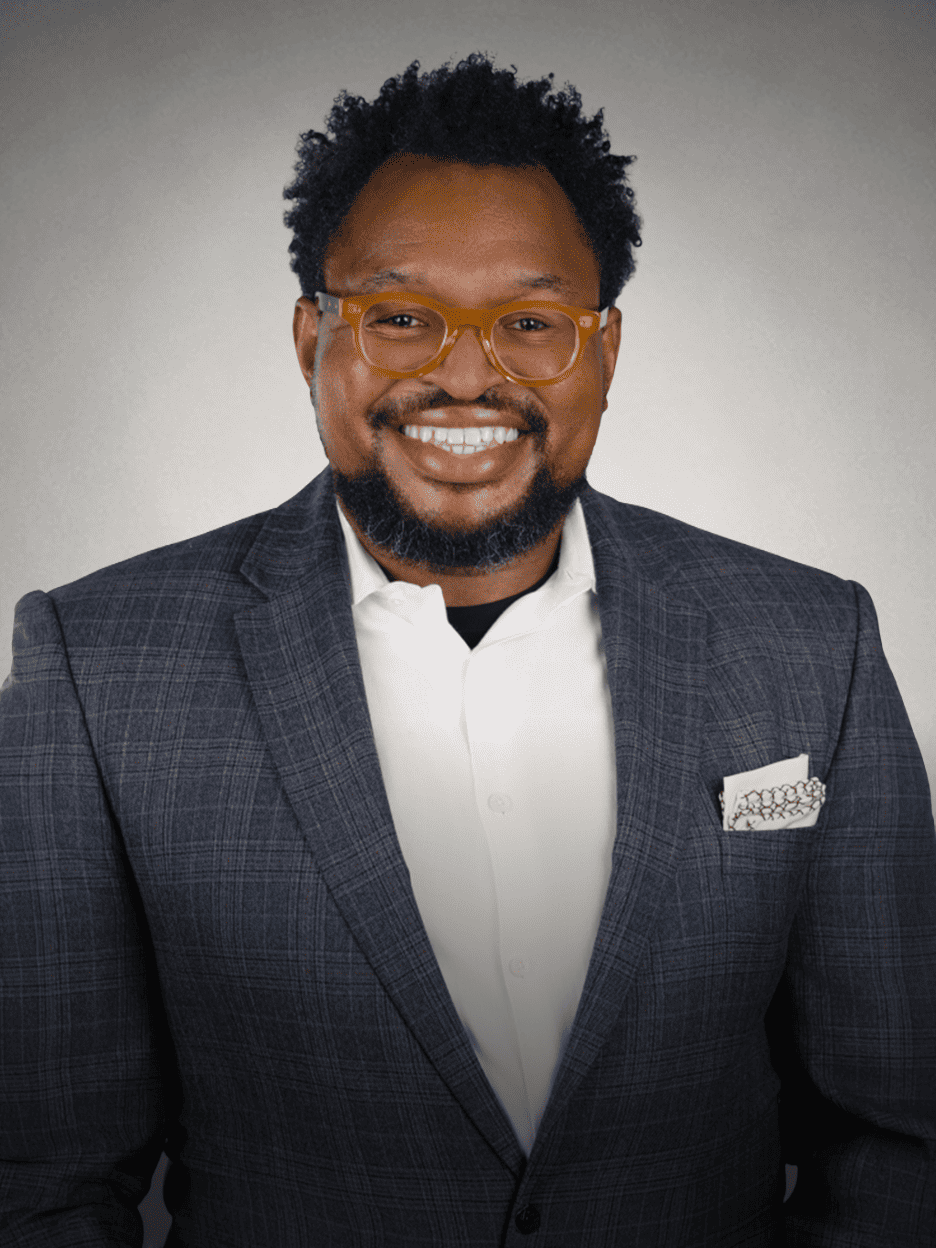 Smiling man with glasses in a business suit for About Us Draft.