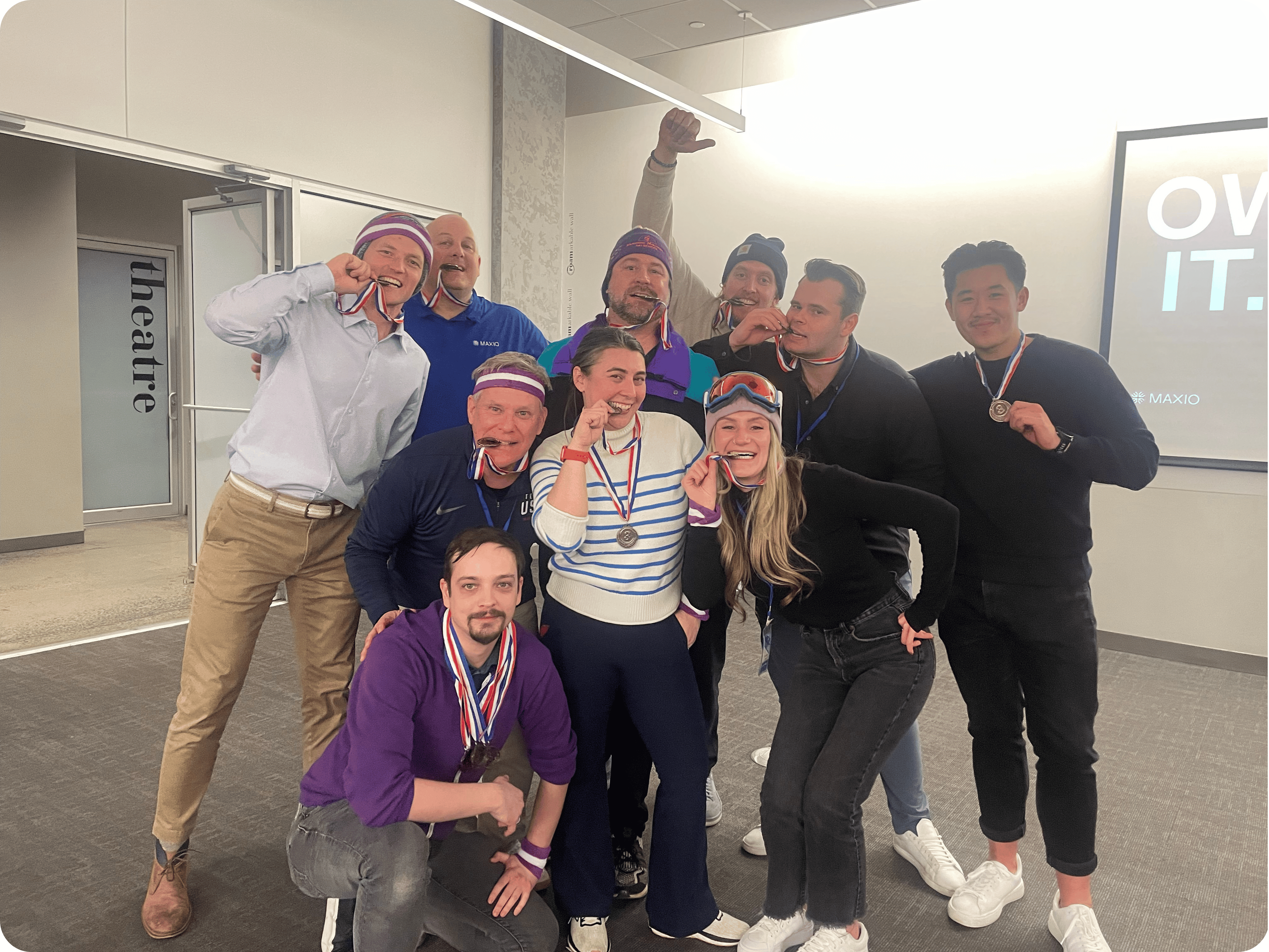 Team celebrating success at Maxio Careers event with medals and smiles.