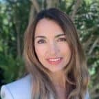Professional woman smiling outdoors, representing Maxio subscription billing services.
