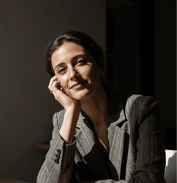 Confident businesswoman in a professional setting, smiling and looking at the camera.