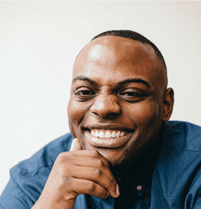 Smiling African American man in business casual attire.